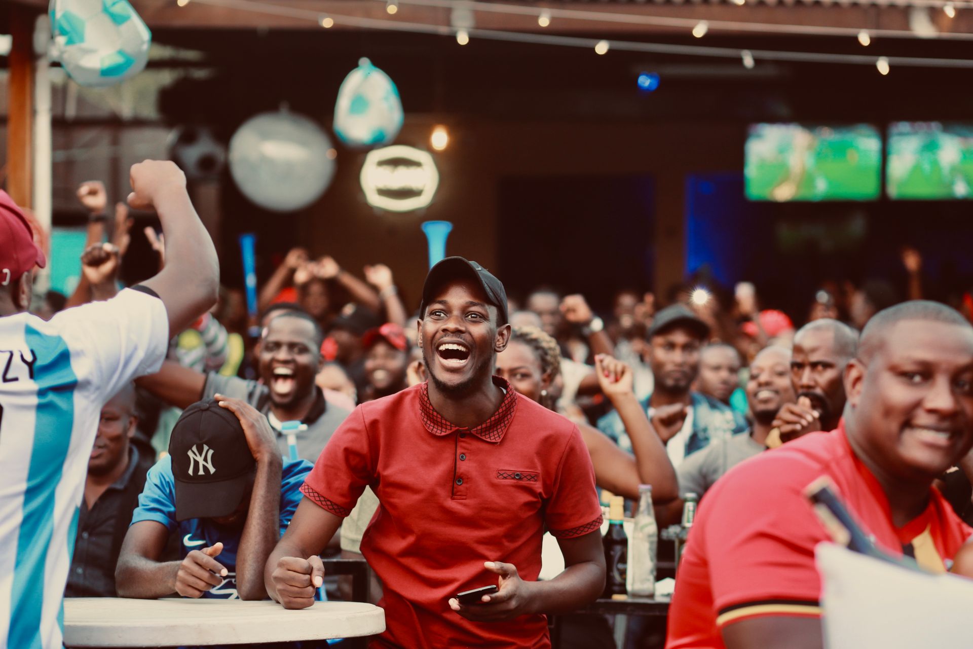 A packed sports bar roaring on a big play